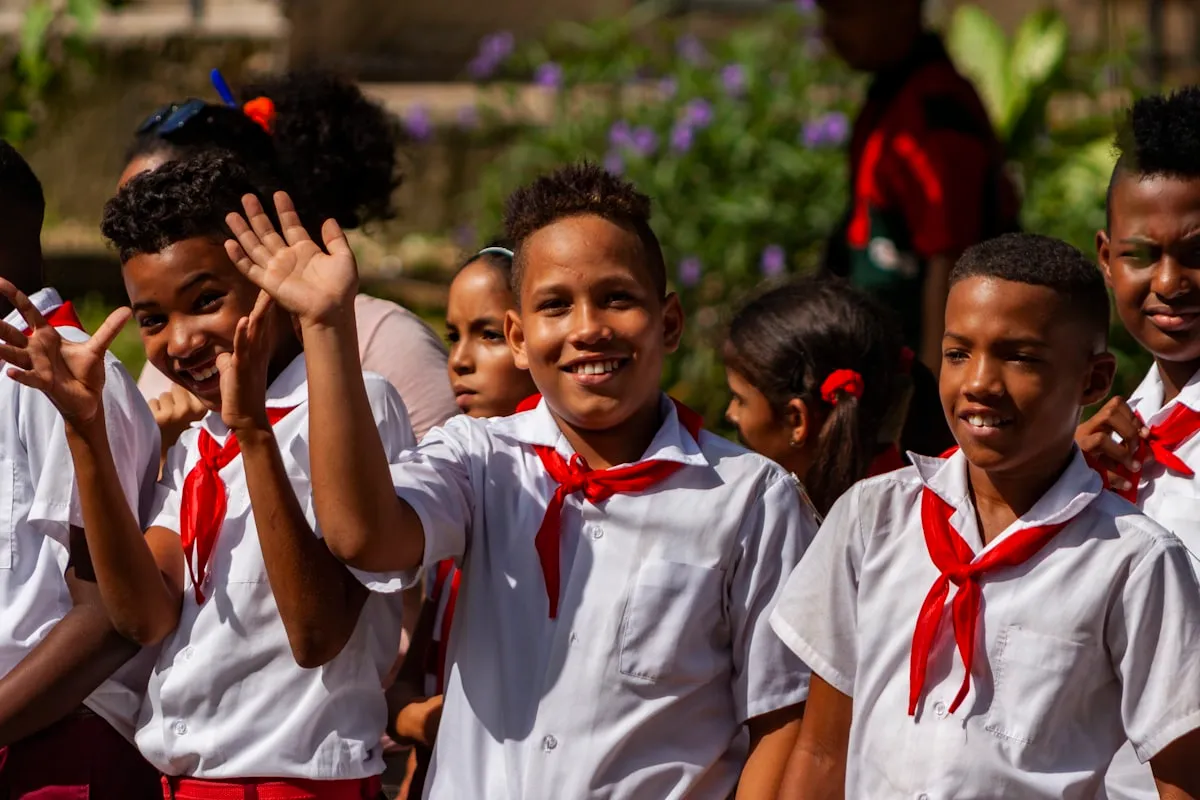 Grupo de niños cantando juntos, con uniforme, sonrientes